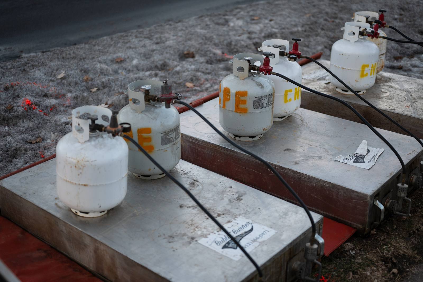 White propane tanks lined up on an outdoor platform.